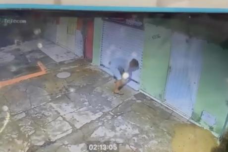 Câmera flagra momento em que homem tenta arrombar porta de loja na Avenida JK